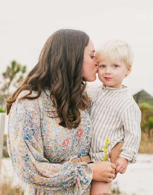 A mother kisses her baby while 30A photographer takes a picture