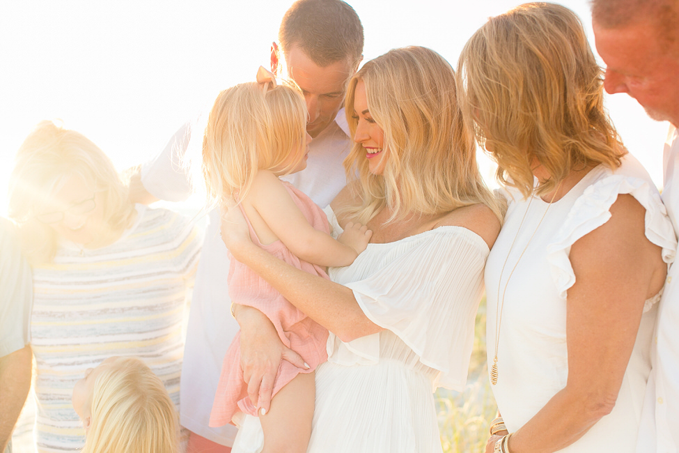 a family poses at sunset on the beach for a 30a photographer
