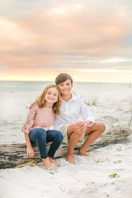 siblings sit on the beach near 30a for a rosemary beach photographer